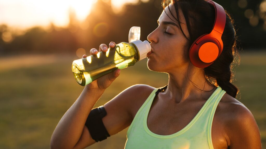 A picture of a runner drinking water.