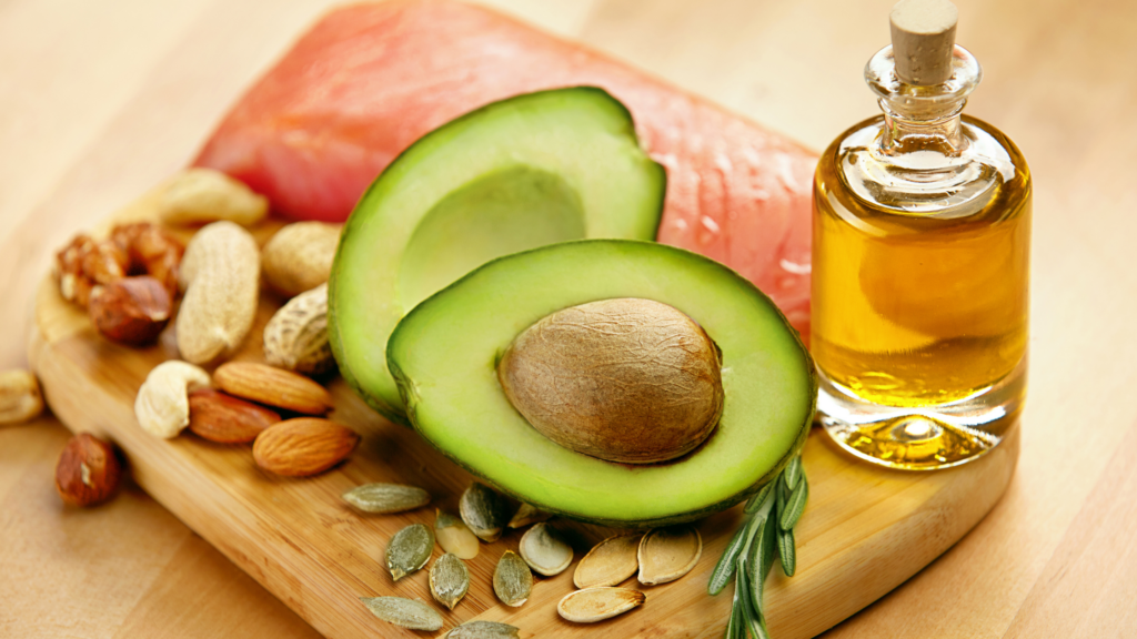 A picture of various fat sources including avocado, oil, nuts, and salmon