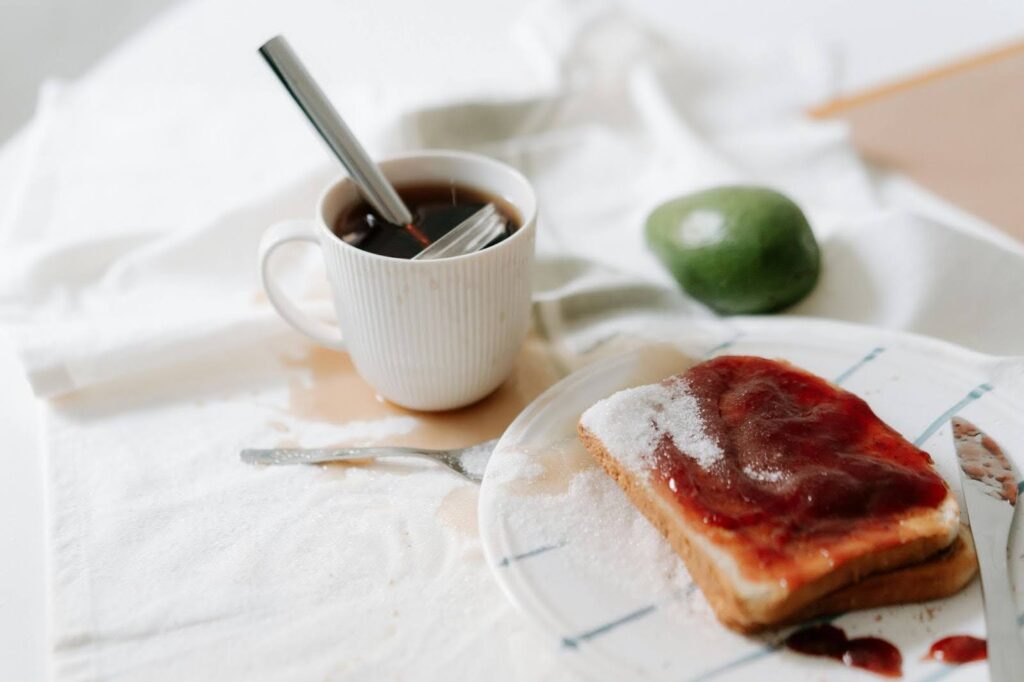 A simple pre-workout breakfast setup with toast topped with jam and a cup of tea, illustrating quick pre workout breakfast ideas, good carbs to eat before a workout, and balanced pre workout meal macros for sustained energy.