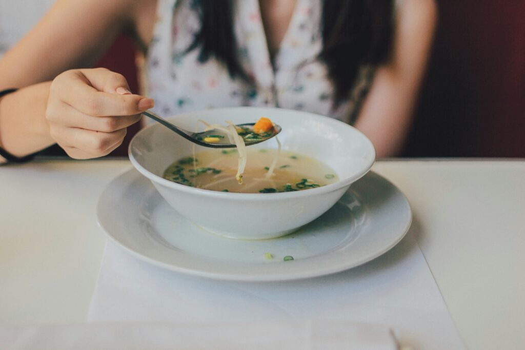 Athlete enjoying a nourishing bowl of soup to support recovery nutrition for athletes, highlighting the role of balanced meals in athlete recovery after training.